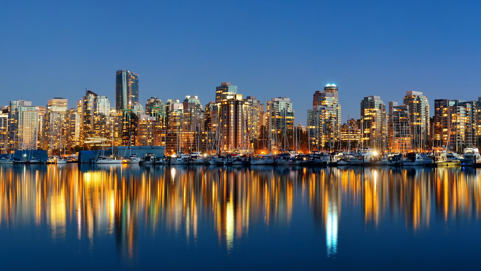 Skyline von Vancouver in der Dämmerung, gespiegelt im Wasser